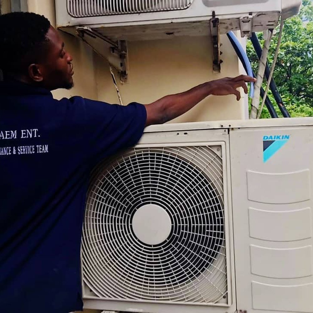JDAEM technician servicing a Daikin outdoor condenser unit in Lagos
