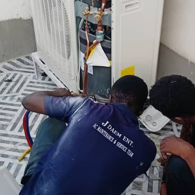 JDAEM engineers connecting refrigerant pipework on a VRF condenser during commissioning